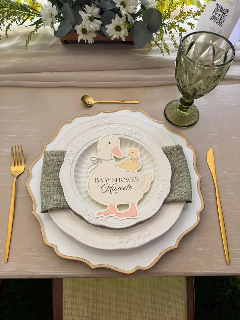Lugar de mesa de baby shower con plato Paula, base Elisa, servilleta salvia y copa verde