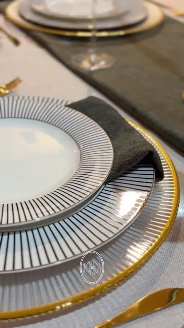 Plato Nápoles sobre base dorada con servilleta gris